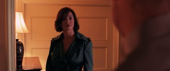 Movie still from “Ocean's Twelve” (2004), directed by Steven Soderbergh – A woman standing in front of a mirror in front of a door; Medium shot, Over the shoulder angle