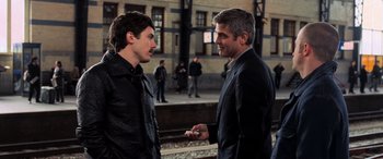 Movie still from “Ocean's Twelve” (2004), directed by Steven Soderbergh – Two men are talking to each other on the sidewalk; Medium shot, Over the shoulder angle