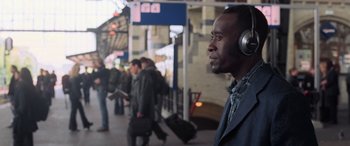 Movie still from “Ocean's Twelve” (2004), directed by Steven Soderbergh – A man with headphones standing on a train platform; Close Up shot, Over the shoulder angle