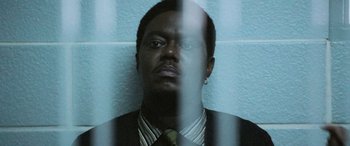 Movie still from “Ocean's Twelve” (2004), directed by Steven Soderbergh – A man wearing a suit and tie in front of a brick wall; Close Up shot, Low angle