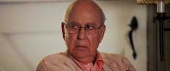 Movie still from “Ocean's Twelve” (2004), directed by Steven Soderbergh – An old man with glasses and a pink shirt; Close Up shot, Over the shoulder angle