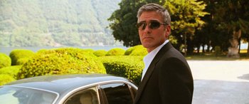 Movie still from “Ocean's Twelve” (2004), directed by Steven Soderbergh – A man standing next to a car in front of bushes; Close Up shot, Low angle