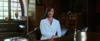 Movie still from “Ocean's Twelve” (2004), directed by Steven Soderbergh – A woman in a white suit sitting in a chair; Medium shot, Over the shoulder angle