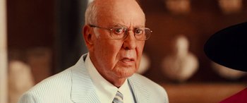 Movie still from “Ocean's Twelve” (2004), directed by Steven Soderbergh – An older man wearing glasses and a suit; Close Up shot, Over the shoulder angle