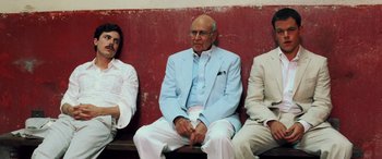 Movie still from “Ocean's Twelve” (2004), directed by Steven Soderbergh – A group of men sitting on top of a wooden bench; Medium shot, Low angle