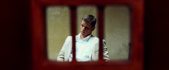 Movie still from “Ocean's Twelve” (2004), directed by Steven Soderbergh – A man sitting in front of a barred window; Medium shot, Low angle