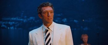 Movie still from “Ocean's Twelve” (2004), directed by Steven Soderbergh – A man in a white suit and a black and white striped tie; Medium shot, Low angle