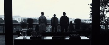Movie still from “Ocean's Twelve” (2004), directed by Steven Soderbergh – A group of men standing in front of a large window; Wide shot, Low angle