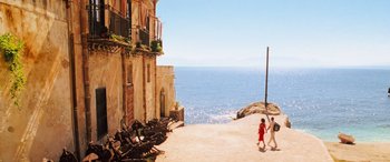 Movie still from “Ocean's Twelve” (2004), directed by Steven Soderbergh – Two people walking on a beach near a building; Extreme Wide shot, High angle