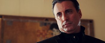 Movie still from “Ocean's Twelve” (2004), directed by Steven Soderbergh – A person wearing a suit and tie; Close Up shot, Low angle