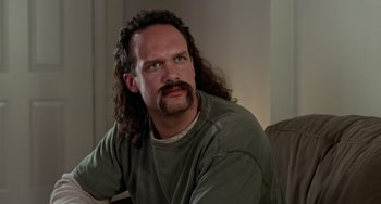 Movie still from “Office Space” (1999), directed by Mike Judge – A man with long hair and a mustache; Close Up shot, Low angle