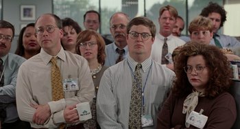 Movie still from “Office Space” (1999), directed by Mike Judge – A group of men and women standing in a room; Medium shot, High angle