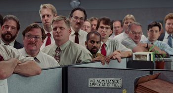 Movie still from “Office Space” (1999), directed by Mike Judge – A group of people in a cubicle with a sign that says no admittance apply at office; Wide shot, Low angle