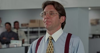 Movie still from “Office Space” (1999), directed by Mike Judge – A person wearing glasses and a tie; Close Up shot, Low angle