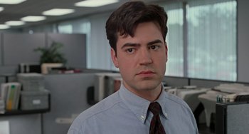 Movie still from “Office Space” (1999), directed by Mike Judge – A man in a shirt and tie in an office setting; Close Up shot, Low angle