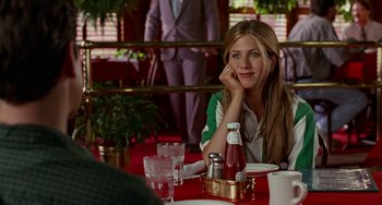 Movie still from “Office Space” (1999), directed by Mike Judge – A beautiful young lady sitting at a table; Medium shot, Over the shoulder angle