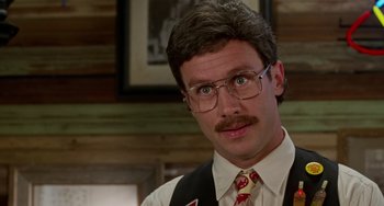 Movie still from “Office Space” (1999), directed by Mike Judge – A man with a mustache wearing glasses and a tie; Close Up shot, Low angle