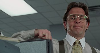 Movie still from “Office Space” (1999), directed by Mike Judge – A man in a suit and tie pointing at a woman in a dress shirt and tie; Medium shot, Low angle