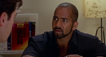 Movie still from “Office Space” (1999), directed by Mike Judge – A person sitting at a table; Close Up shot, Over the shoulder angle