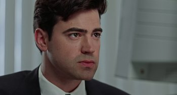 Movie still from “Office Space” (1999), directed by Mike Judge – A person wearing a suit and tie; Close Up shot, Low angle