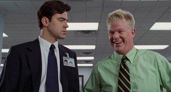Movie still from “Office Space” (1999), directed by Mike Judge – Two men standing next to each other in an office; Medium shot, Over the shoulder angle