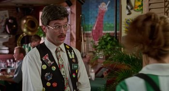 Movie still from “Office Space” (1999), directed by Mike Judge – A man with many buttons on his vest and tie; Close Up shot, Over the shoulder angle