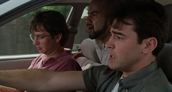 Movie still from “Office Space” (1999), directed by Mike Judge – A group of people sitting in a car; Medium shot, Low angle