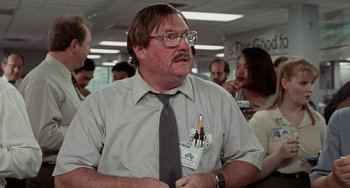 Movie still from “Office Space” (1999), directed by Mike Judge – A man in a tie and glasses is holding a pencil in his mouth; Medium shot, Low angle