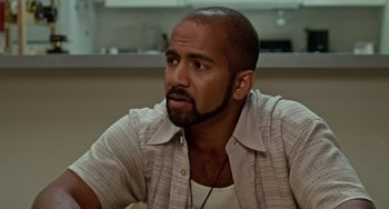 Movie still from “Office Space” (1999), directed by Mike Judge – A man with a beard is sitting in a room; Close Up shot, High angle