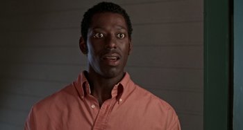 Movie still from “Office Space” (1999), directed by Mike Judge – A black man wearing a pink shirt looking surprised; Close Up shot, Low angle