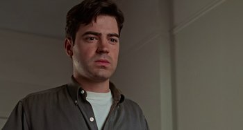 Movie still from “Office Space” (1999), directed by Mike Judge – A person wearing a shirt and looking at the camera; Close Up shot, Low angle