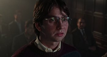 Movie still from “Office Space” (1999), directed by Mike Judge – A man with glasses is looking at the camera; Close Up shot, Low angle