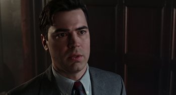 Movie still from “Office Space” (1999), directed by Mike Judge – A person wearing a suit and tie; Close Up shot, Over the shoulder angle