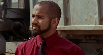 Movie still from “Office Space” (1999), directed by Mike Judge – A man in a red shirt and a black tie; Close Up shot, Over the shoulder angle