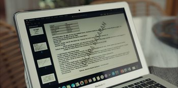 Movie still from “Oh Belinda” (2023), directed by Deniz Yorulmazer – An open laptop computer sitting on top of a desk; Extreme Close Up shot, High angle