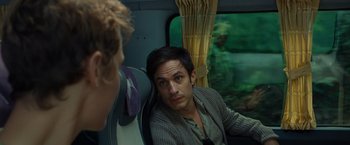 Movie still from “Old” (2021), directed by M. Night Shyamalan – A man sitting on a train looking at the camera; Close Up shot, Over the shoulder angle