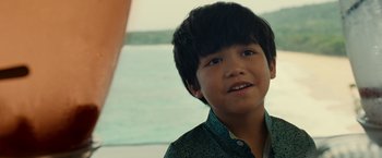 Movie still from “Old” (2021), directed by M. Night Shyamalan – A young boy is smiling for the camera; Close Up shot, Over the shoulder angle