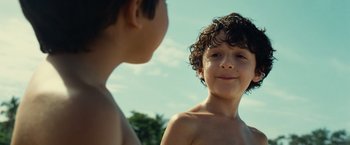 Movie still from “Old” (2021), directed by M. Night Shyamalan – Two young boys standing next to each other in the sun; Close Up shot, Low angle