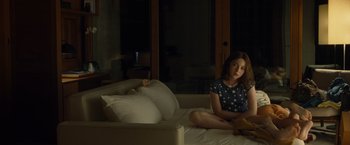 Movie still from “Old” (2021), directed by M. Night Shyamalan – A girl sitting on a bed in a dark room; Medium shot, Over the shoulder angle