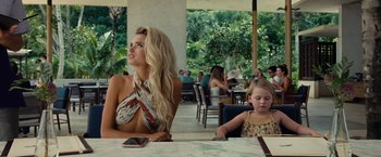 Movie still from “Old” (2021), directed by M. Night Shyamalan – A woman sitting at a table next to a little girl; Medium shot, Over the shoulder angle