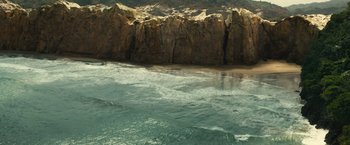 Movie still from “Old” (2021), directed by M. Night Shyamalan – A body of water near a rocky cliff; Extreme Wide shot, High angle