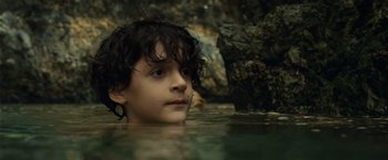 Movie still from “Old” (2021), directed by M. Night Shyamalan – A young boy in a body of water; Close Up shot, Low angle