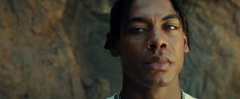 Movie still from “Old” (2021), directed by M. Night Shyamalan – A man's face in front of a stone wall; Close Up shot, Low angle