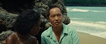 Movie still from “Old” (2021), directed by M. Night Shyamalan – A man and a woman are sitting next to a tree; Close Up shot, Over the shoulder angle