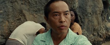 Movie still from “Old” (2021), directed by M. Night Shyamalan – A person wearing a green shirt; Close Up shot, Low angle