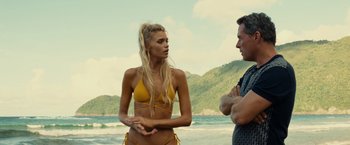 Movie still from “Old” (2021), directed by M. Night Shyamalan – A woman in a yellow bathing suit standing next to a man; Medium shot, Over the shoulder angle