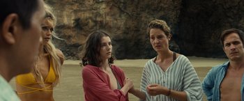 Movie still from “Old” (2021), directed by M. Night Shyamalan – Two women standing next to each other on the beach; Medium shot, Low angle