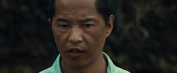 Movie still from “Old” (2021), directed by M. Night Shyamalan – A man's face in a green shirt; Close Up shot, Low angle