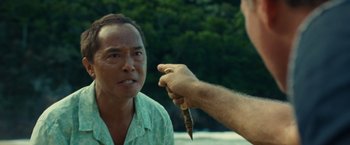 Movie still from “Old” (2021), directed by M. Night Shyamalan – A man holding a knife in front of another man; Close Up shot, Over the shoulder angle