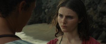 Movie still from “Old” (2021), directed by M. Night Shyamalan – A young woman looking at the camera while standing next to a man; Close Up shot, Over the shoulder angle